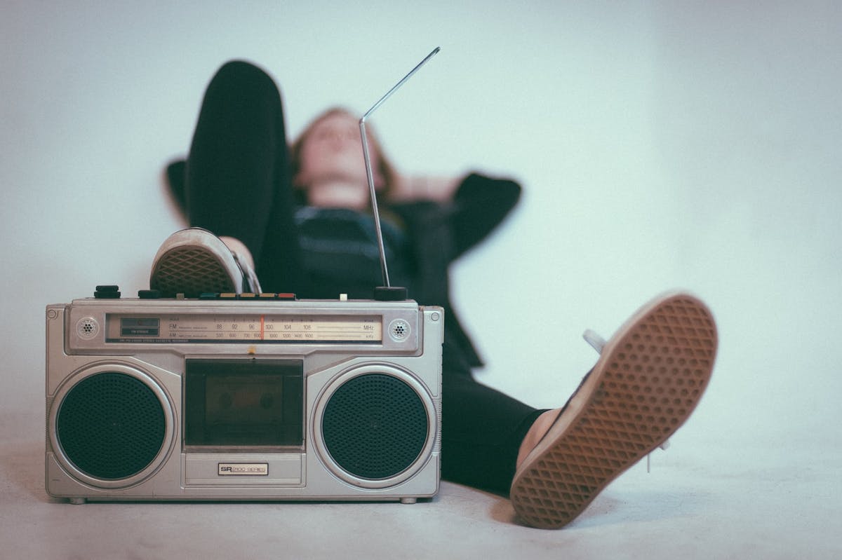 woman lounging with boombox listening to writing playlists - Photo by Eric Nopanen on Unsplash