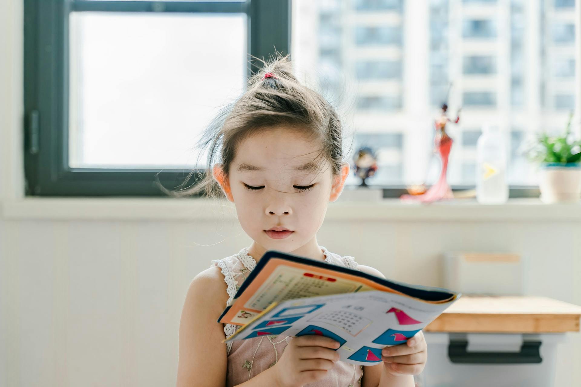little girl reading - Photo by Jerry Wang on Unsplash